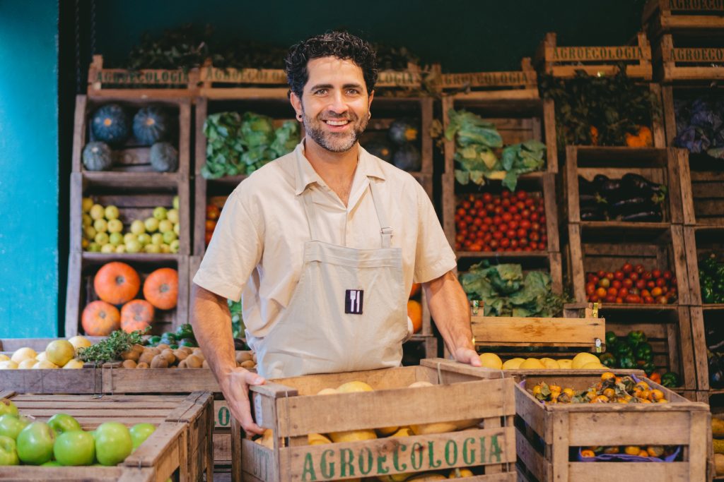 Middleaged Latin Man Smiling With Crate Pumpkins Vegetable Store While Looking Camera 1 1024x683